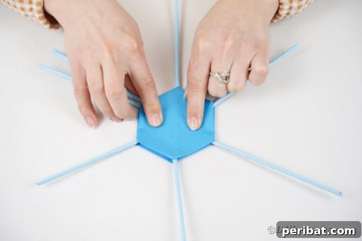 Vibrant DIY Paper Straw Desk Caddy 24 The second hexagonal paper base is being glued on top of the standing paper straws, securing the initial structure.
