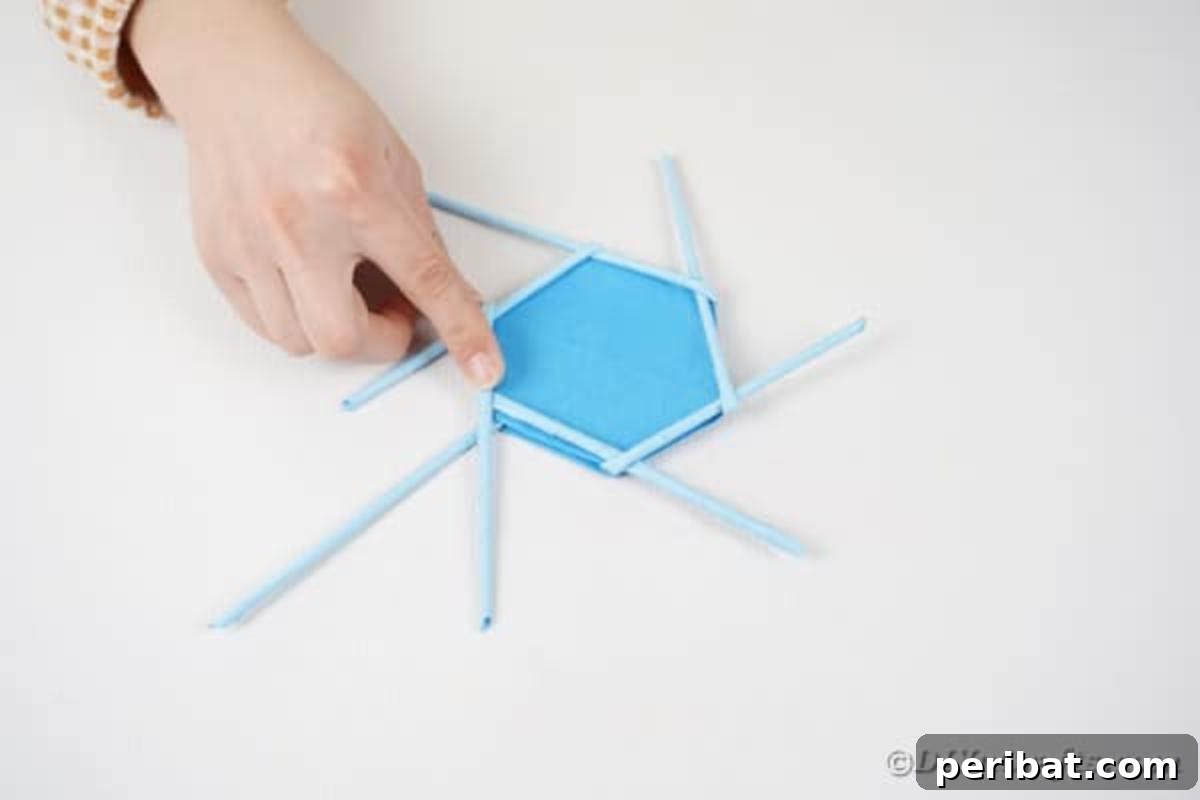 Vibrant DIY Paper Straw Desk Caddy 25 A paper straw is being folded and woven to the left, aligning with the base of the polygon.