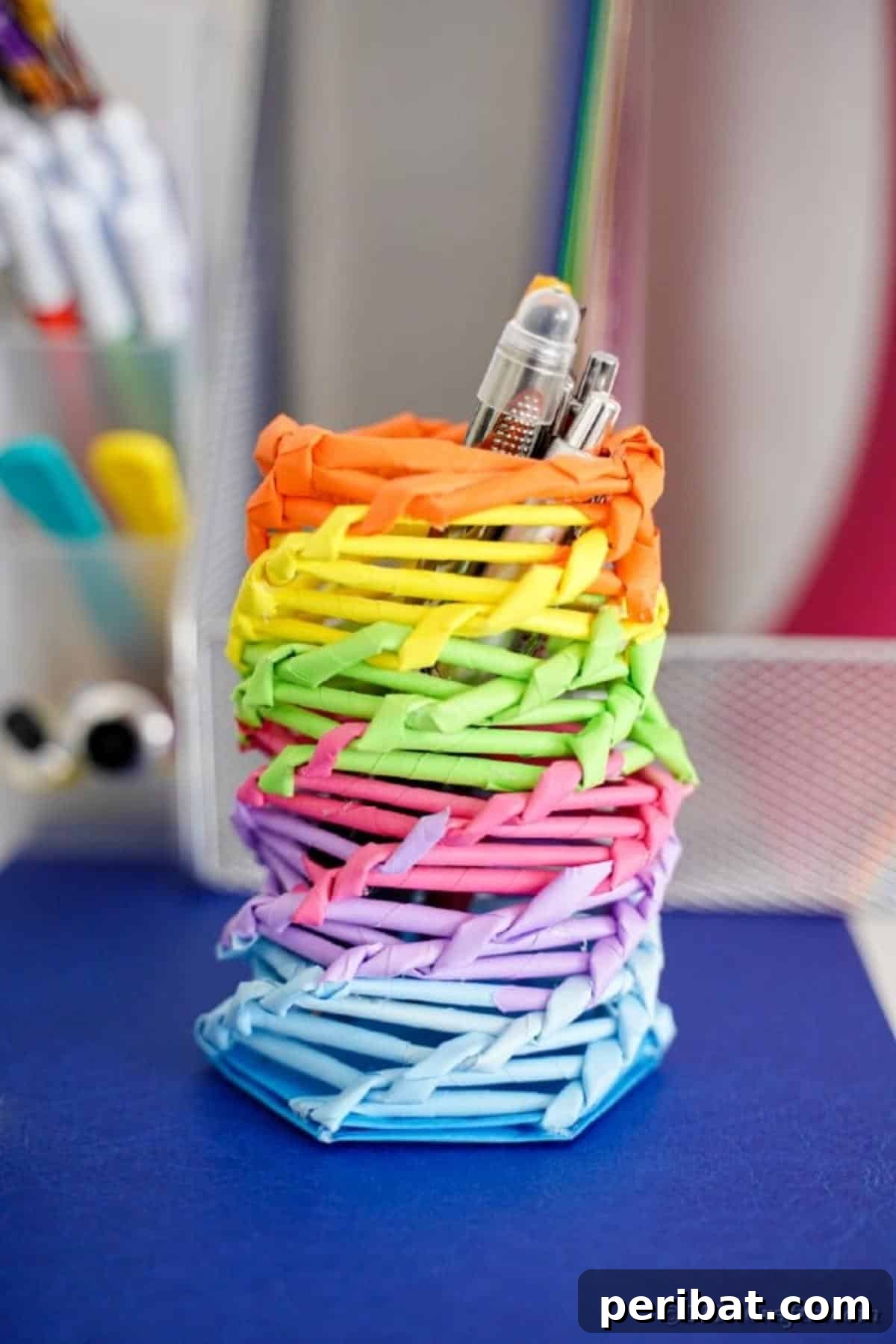 Vibrant DIY Paper Straw Desk Caddy 4 Close-up of the rainbow organizer can on a desk, positioned near various papers and office supplies.
