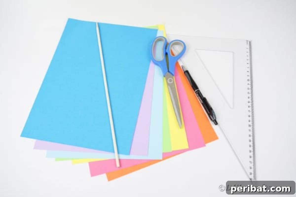 Vibrant DIY Paper Straw Desk Caddy 6 An array of craft supplies laid out on a surface, including rainbow colored paper, a glue gun, ruler, pen, and scissors, ready for making the straw organizer.