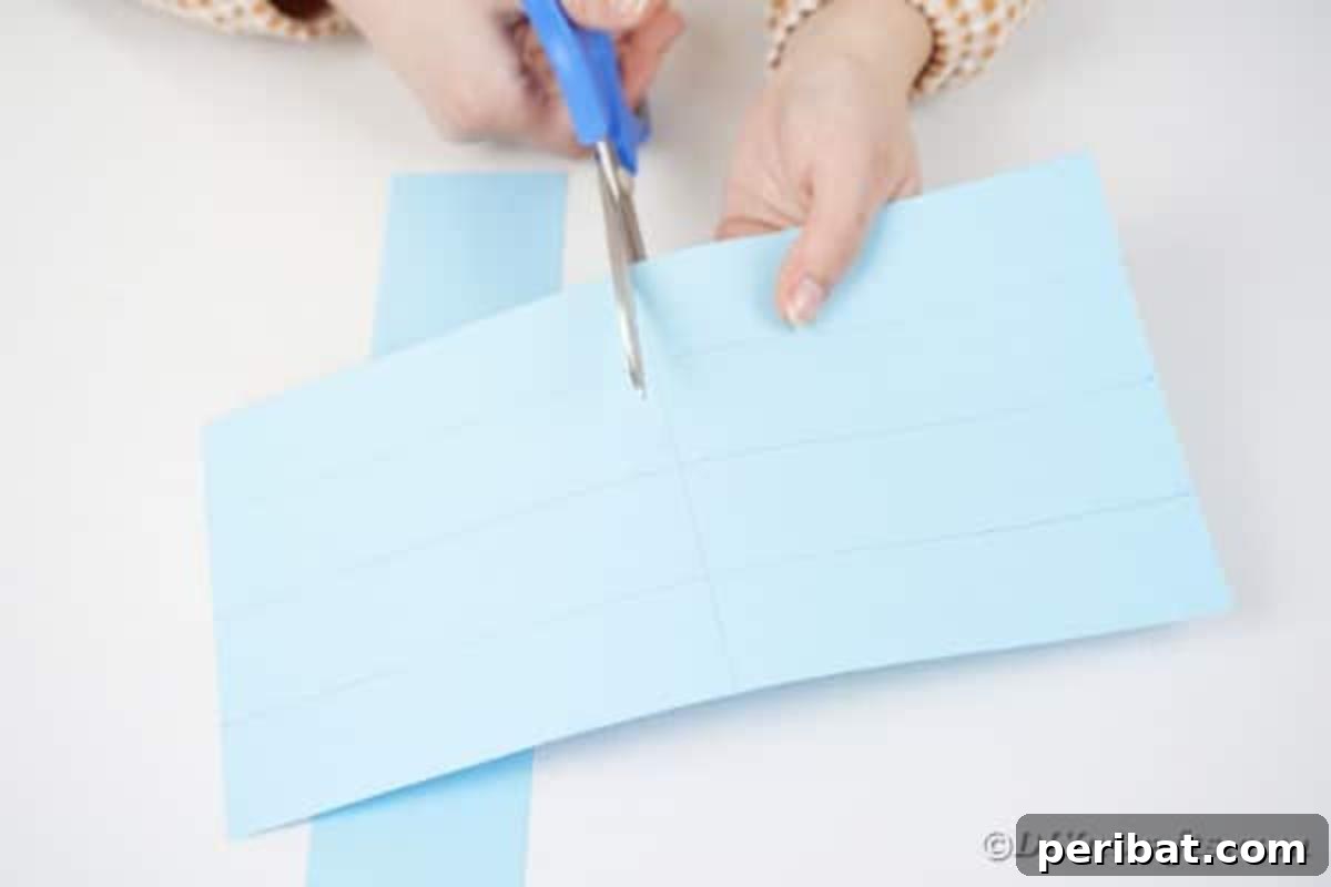 Vibrant DIY Paper Straw Desk Caddy 9 Hands are shown cutting a sheet of paper in half along a drawn line.