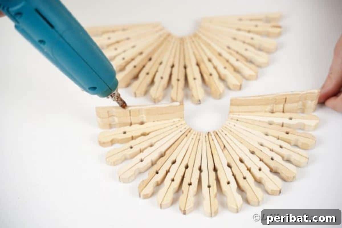 Chic Repurposed Clothespin Napkin Rack 13 One of the small glued clothespin blocks is being attached to the bottom edge of a half-circle side, forming the base.