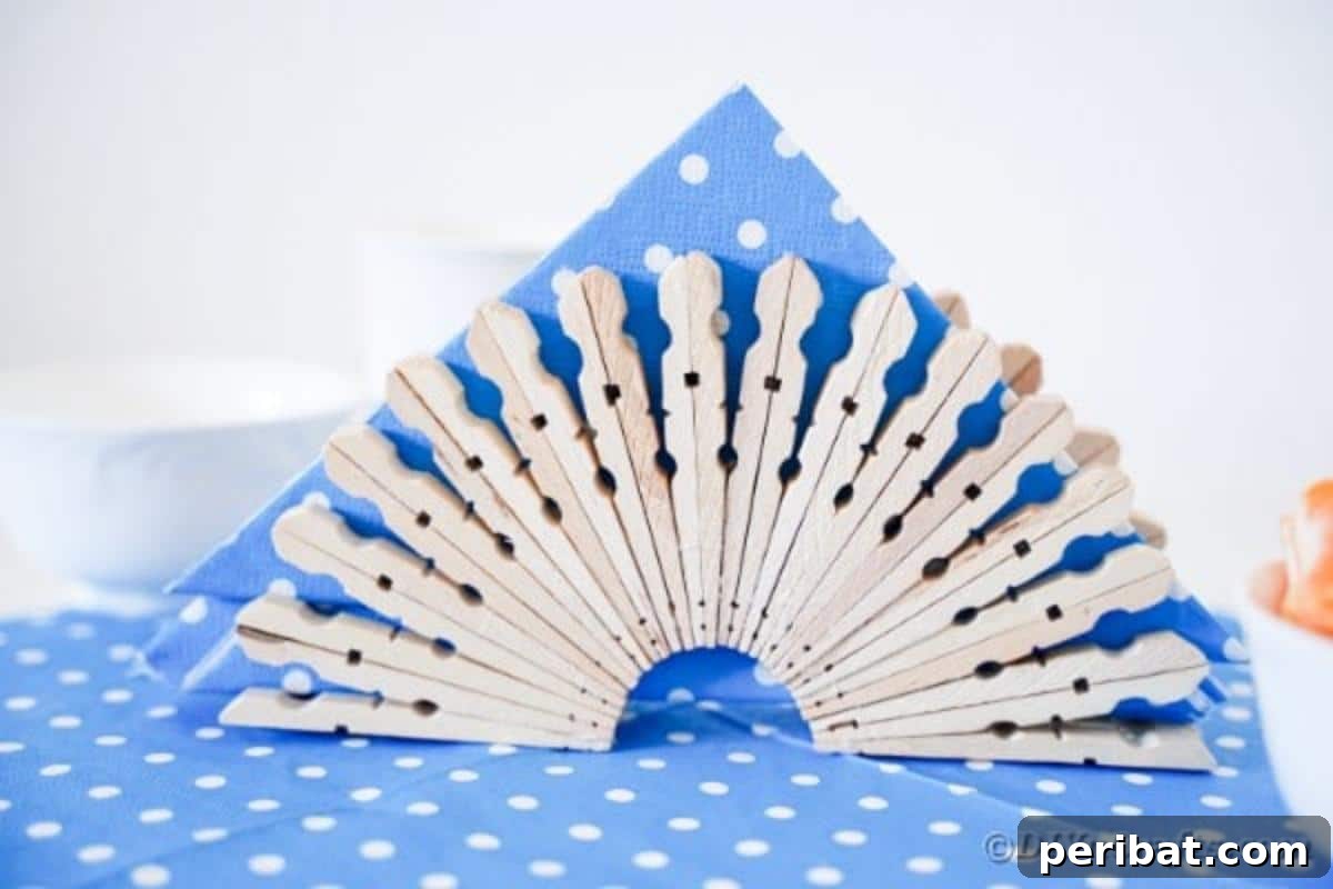 Chic Repurposed Clothespin Napkin Rack 15 The completed clothespin napkin holder is beautifully placed on a blue and white polka dot cloth, filled with napkins.