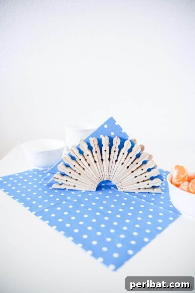 Chic Repurposed Clothespin Napkin Rack 18 The charming clothespin napkin holder is set on a blue and white polka dot cloth, ready for use.