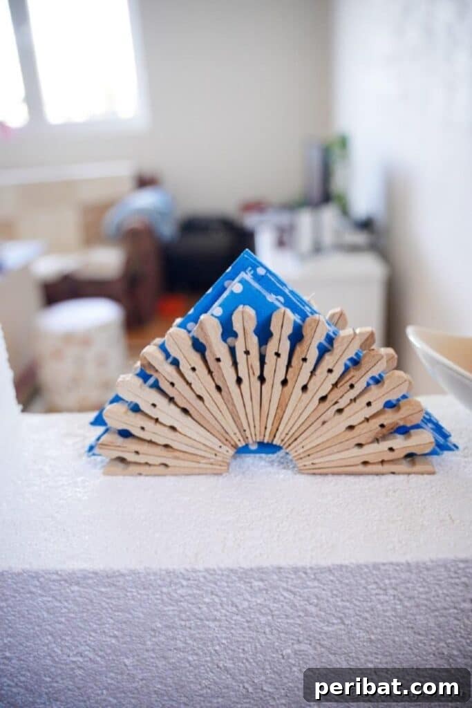 Chic Repurposed Clothespin Napkin Rack 19 Another perspective of the clothespin napkin holder, elegantly placed on a blue and white polka dot tablecloth.
