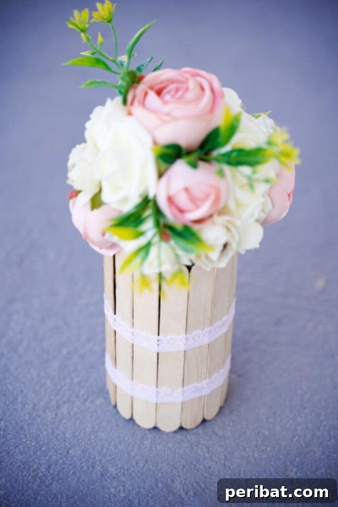 Transform Tin Cans into a Rustic Craft Stick Organizer Video Tutorial 18 Craft stick vase with white and pink flowers on sidewalk