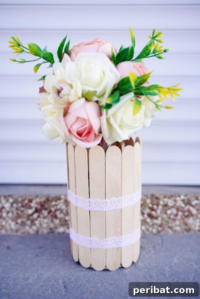 Transform Tin Cans into a Rustic Craft Stick Organizer Video Tutorial 20 Craft stick vase with white and pink flowers on sidewalk