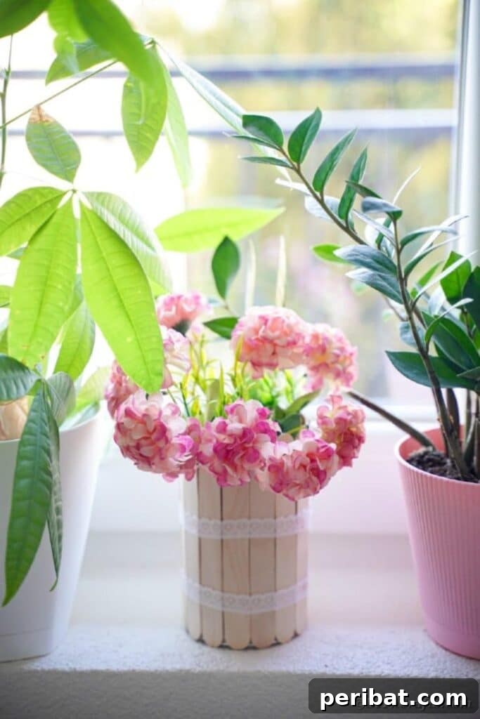 Transform Tin Cans into a Rustic Craft Stick Organizer Video Tutorial 23 Craft stick can with pink flowers on windowsill
