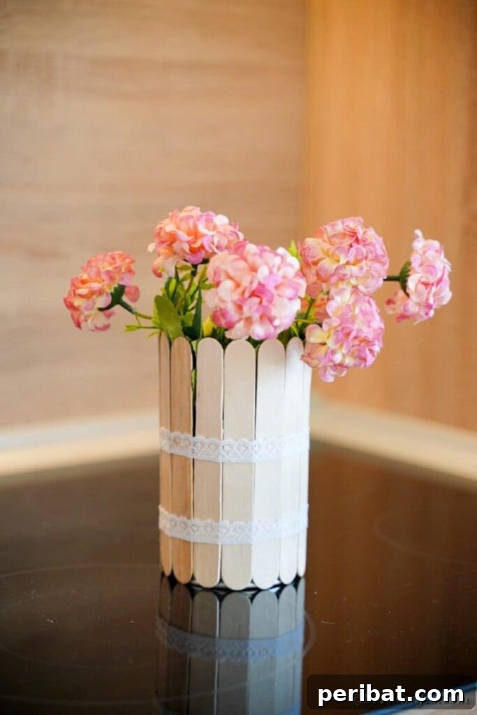 Transform Tin Cans into a Rustic Craft Stick Organizer Video Tutorial 26 Craft stick can with pink flowers on wood table