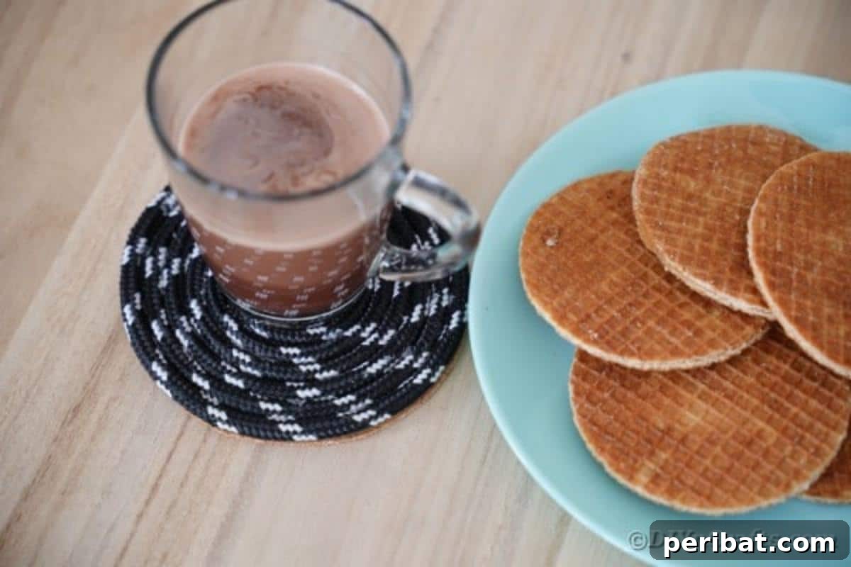Coffee cup on coaster by plate of waffles