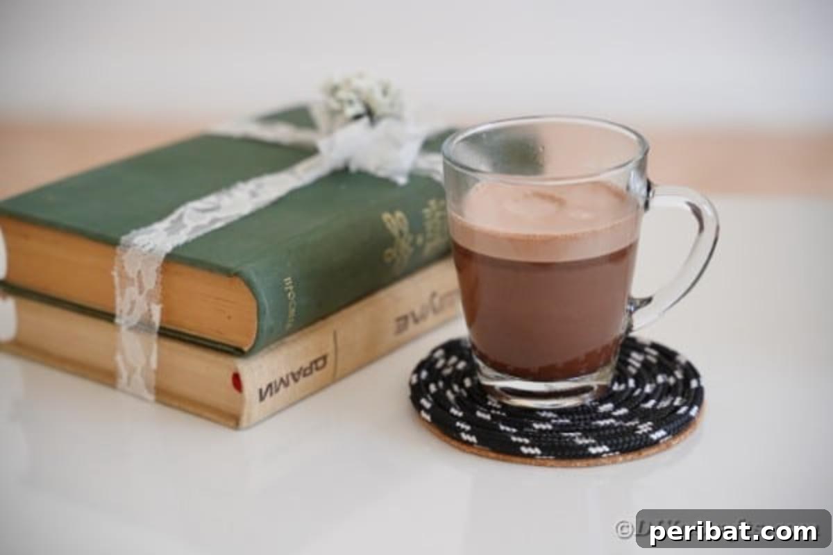Glass of coffee on black coaster on side table by books