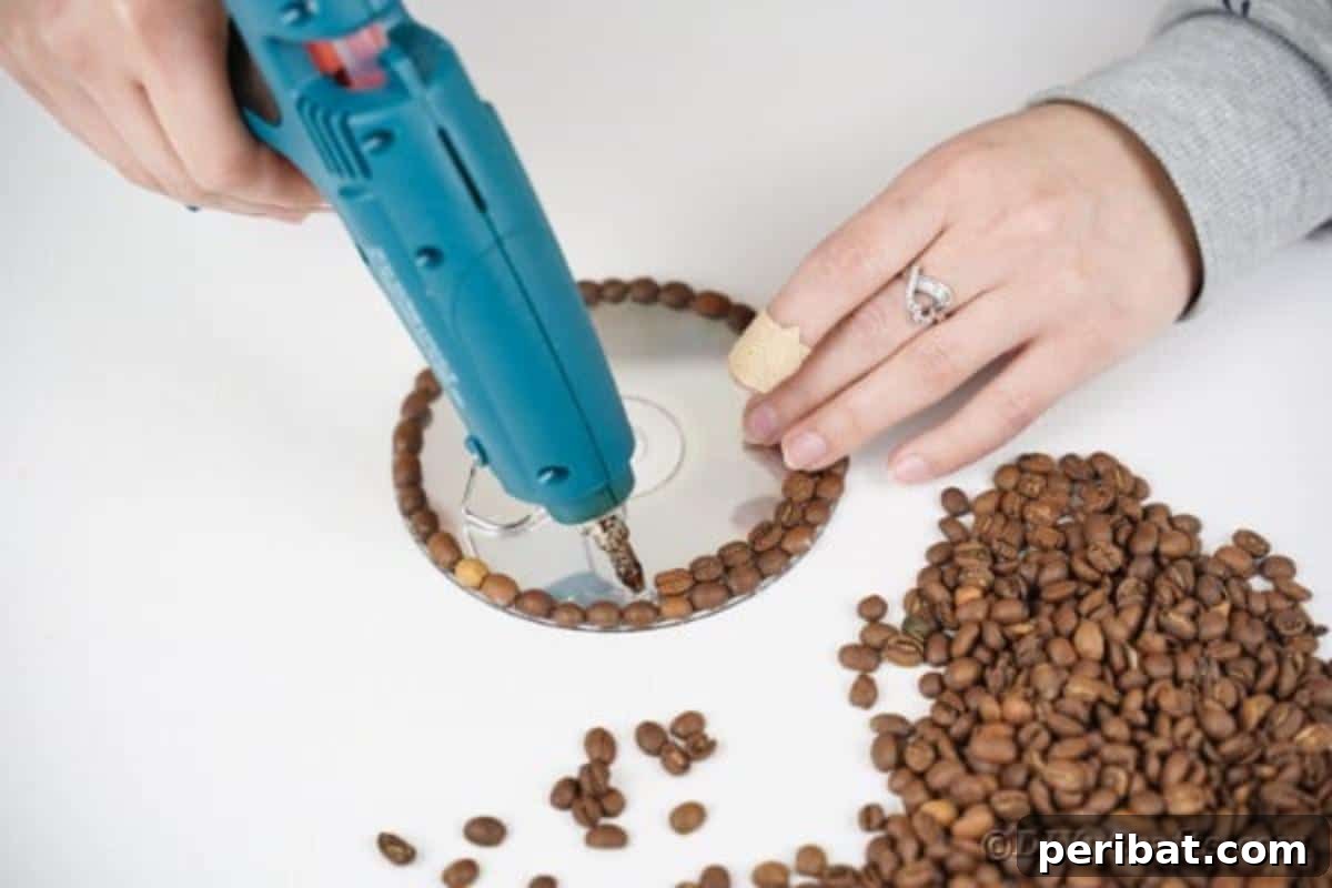 Second step: Continuing to glue coffee beans in a circular fashion towards the center of the CD.