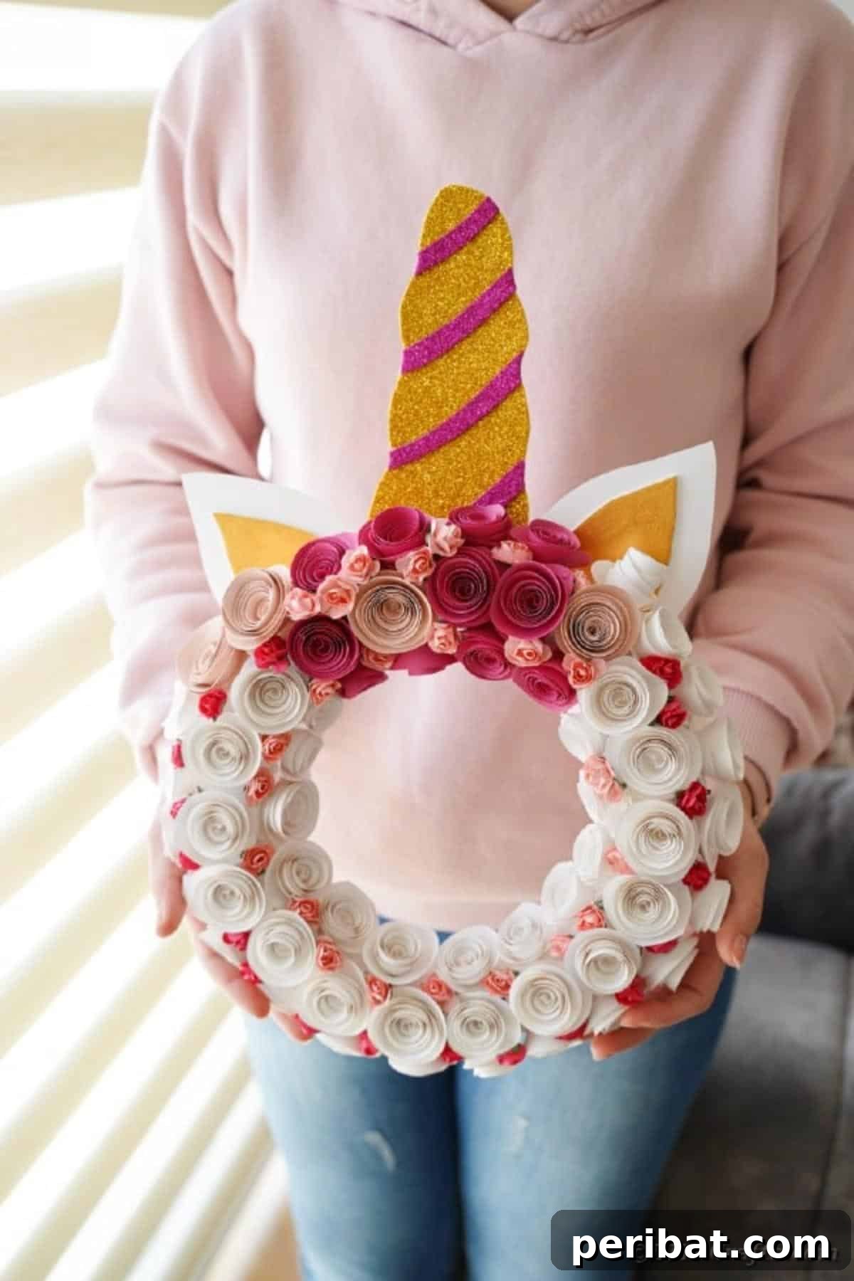 Enchanting Quilled Unicorn Wreath 20 A woman proudly holding the finished paper unicorn wreath, showcasing its full design and scale against a neutral background.