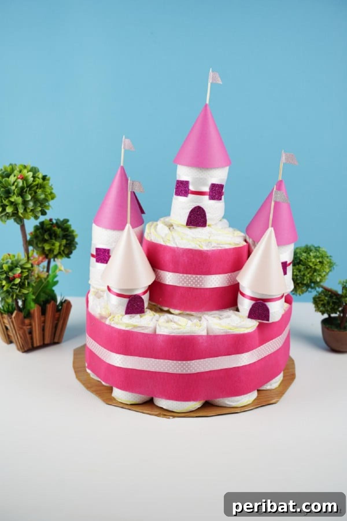 Kraliyet Bez Şato: Bebek Duşu İçin Özel El Yapımı Hediye 31 Diaper cake with elegant pink ribbons against a soft blue background