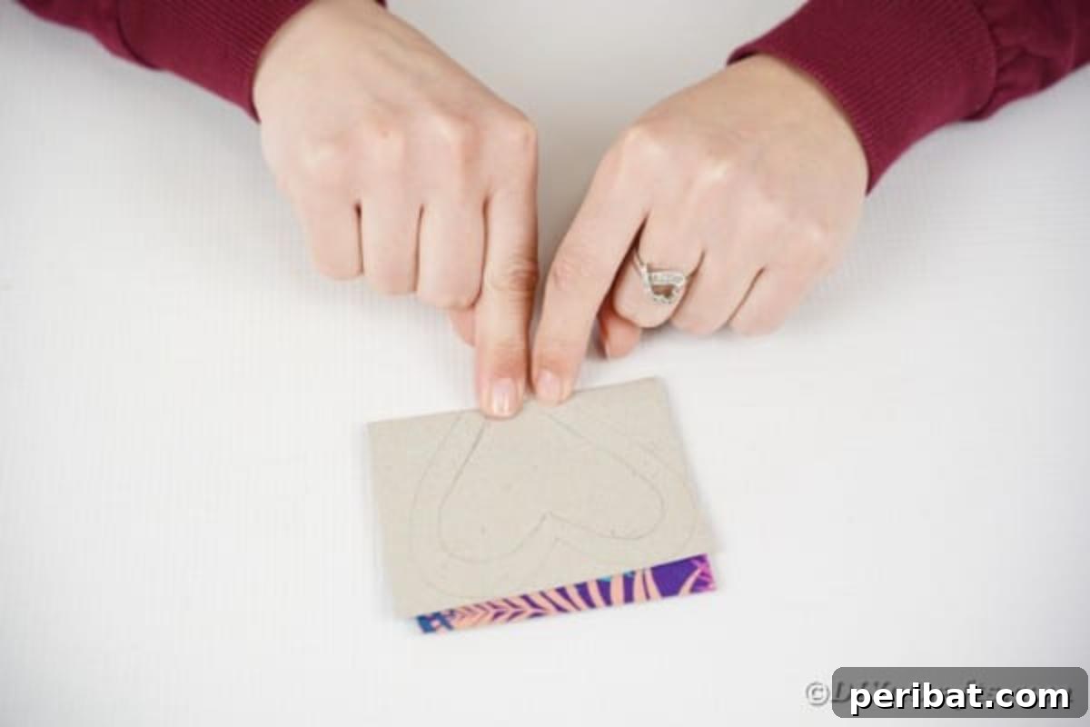 A piece of craft paper being folded precisely in half, illustrating a key step for creating symmetrical butterfly wings.