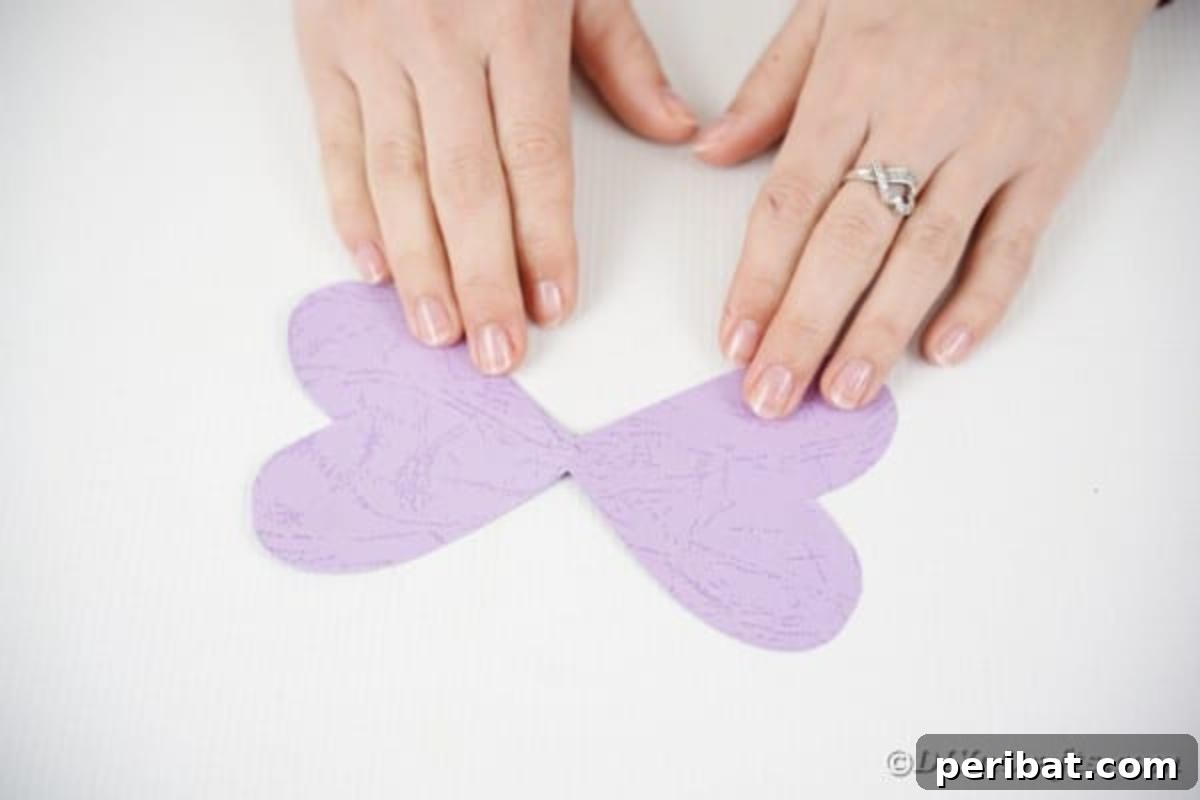 A single, perfectly cut purple butterfly wing crafted from solid paper, ready for the next stage of assembly.