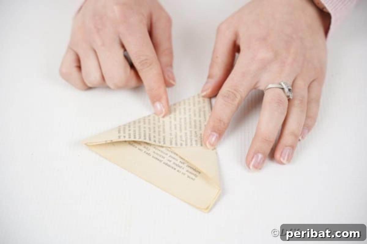 Paper being folded into a triangle shape for cutting rose petals.