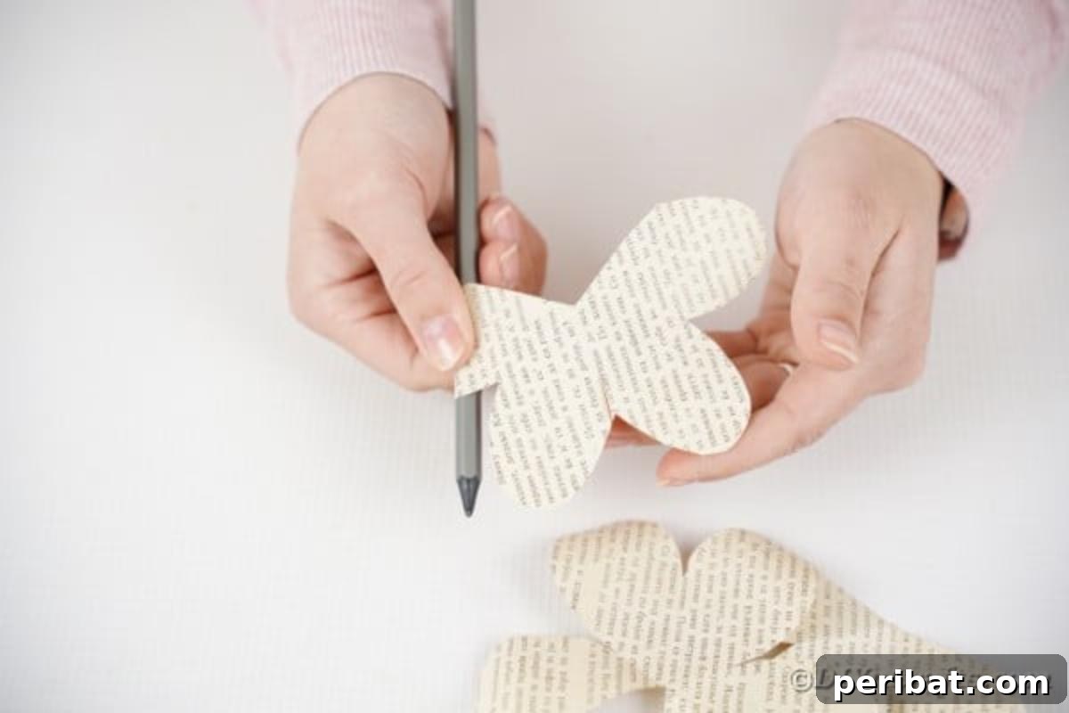 Scissors cutting two petals from a paper rose, for layered construction.