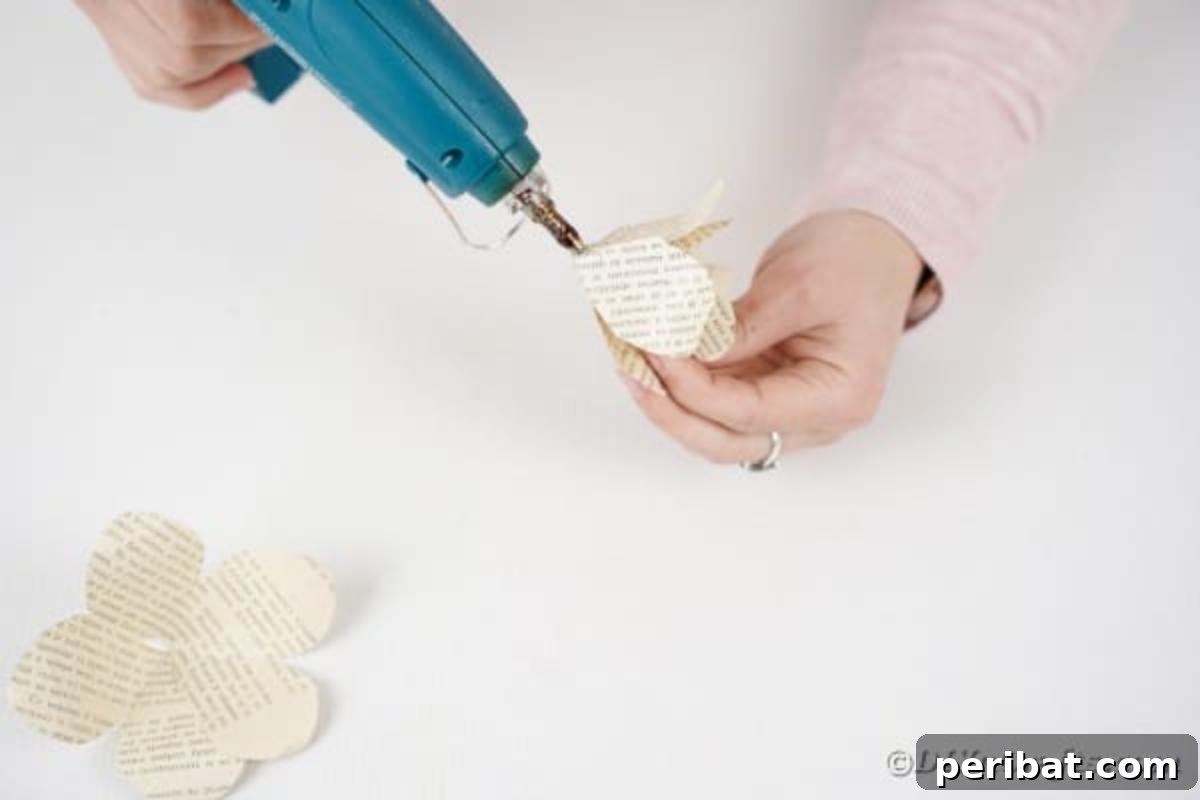 A paper rose being assembled, with smaller petal sections glued into larger ones.