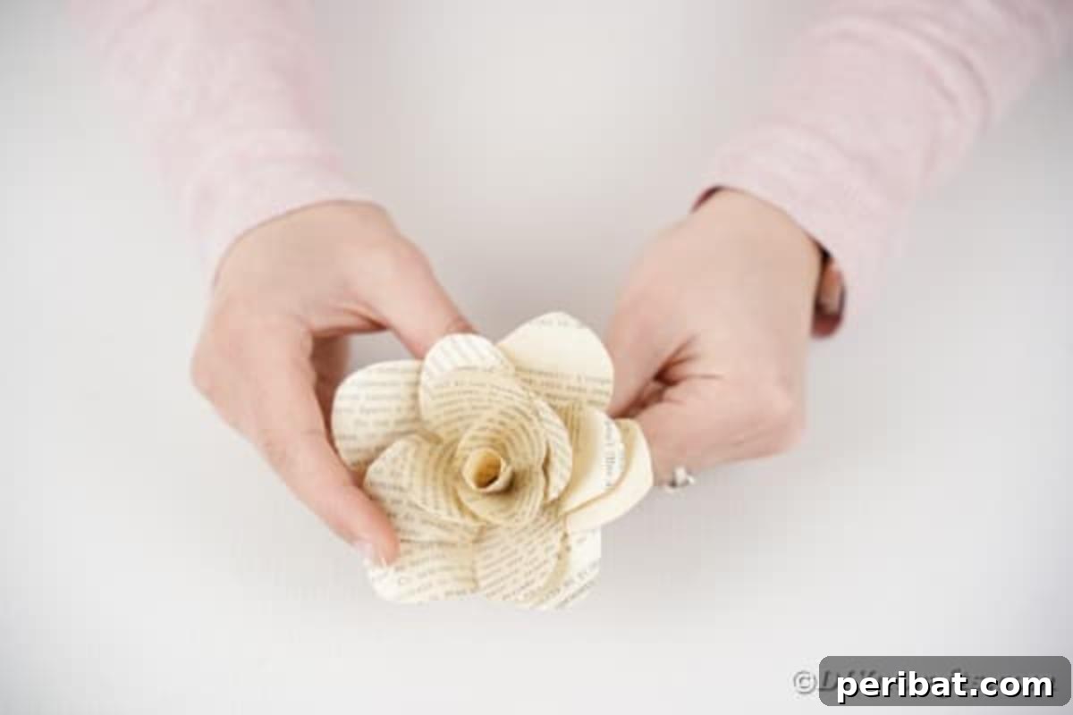 A partially assembled paper rose, showing the technique of shaping petals for a realistic look.