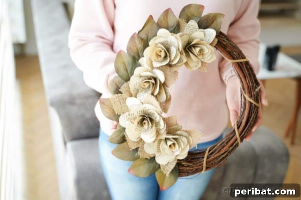 Close-up of a woman holding a handmade book page rose wreath, highlighting the intricate details of the paper flowers.