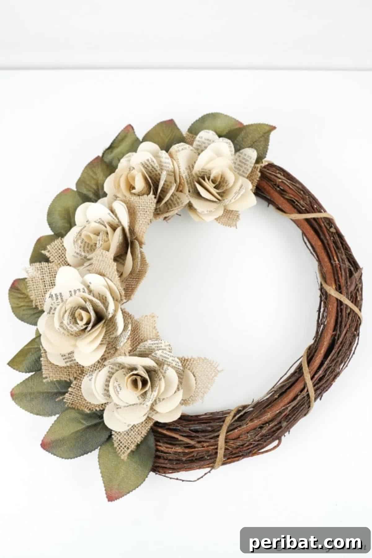 A completed book page wreath hanging against a white background, ready for display.
