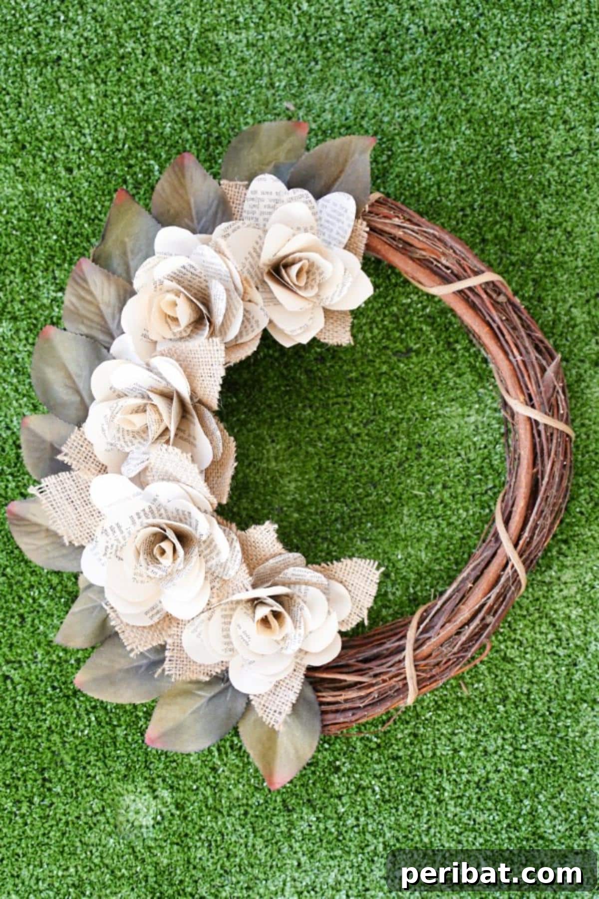 The rustic book page wreath elegantly positioned on green grass, highlighting its natural and organic elements.