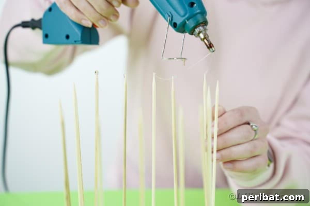 Crafting a Beautiful Floral Birdcage Display 12 Gluing End of Skewers - Applying hot glue to the top of the skewers.