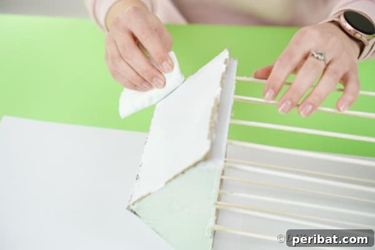 Crafting a Beautiful Floral Birdcage Display 19 Rubbing Paint Off Edges of Cage Roof - Gently removing paint for a distressed, rustic finish.