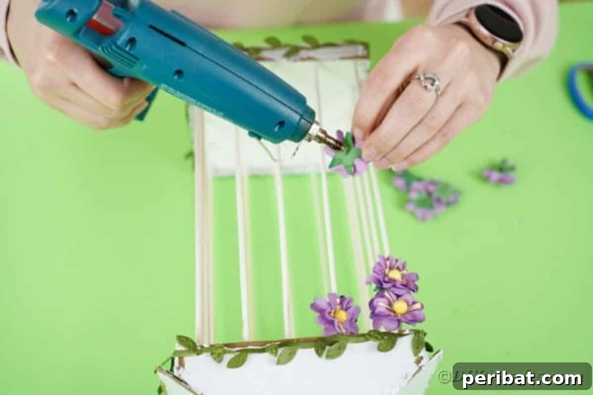 Crafting a Beautiful Floral Birdcage Display 21 Gluing Flowers Onto Birdcage - Attaching artificial flowers to the birdcage for decoration.