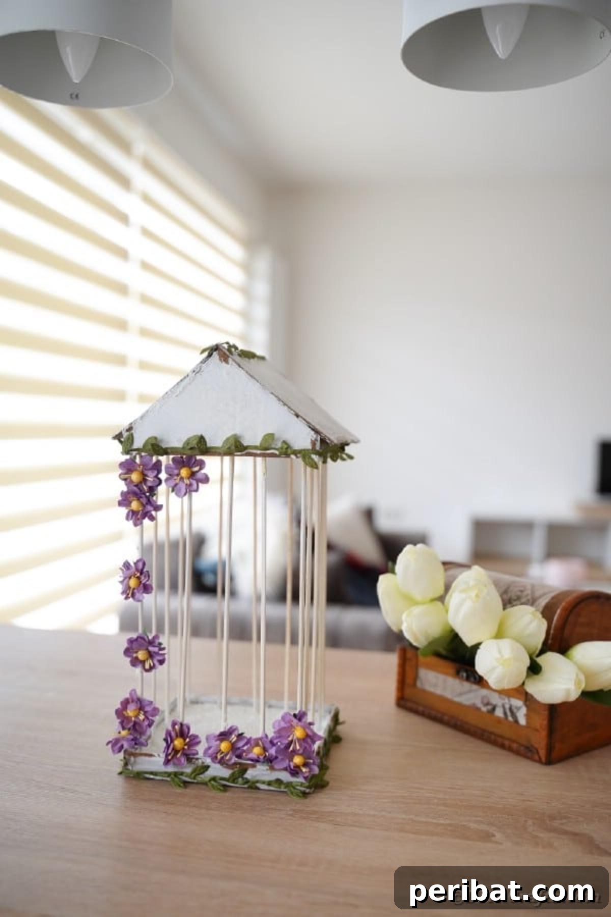 Crafting a Beautiful Floral Birdcage Display 23 DIY Birdcage on Table by Tulips - A charming decorative birdcage featuring purple flowers and green ivy, placed beside fresh pink tulips on a rustic wooden table, enhancing a cozy, springtime atmosphere. Perfect for home decor enthusiasts.