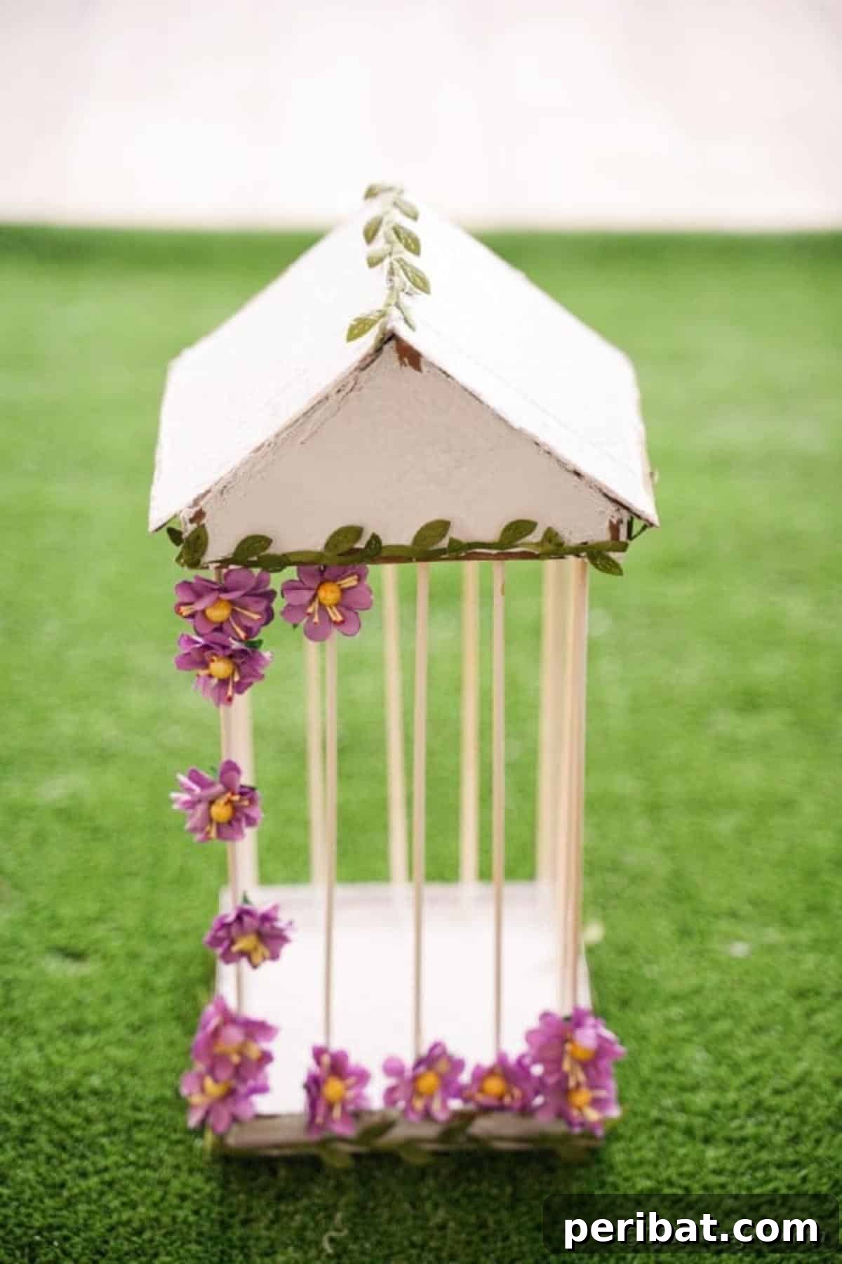 Crafting a Beautiful Floral Birdcage Display 28 Homemade Bird Cage on Grass (Close-up) - A detailed view of the decorative homemade birdcage sitting on grass, showcasing the texture of the distressed paint and the delicate artificial flowers. Emphasizes the handcrafted quality for DIY projects.
