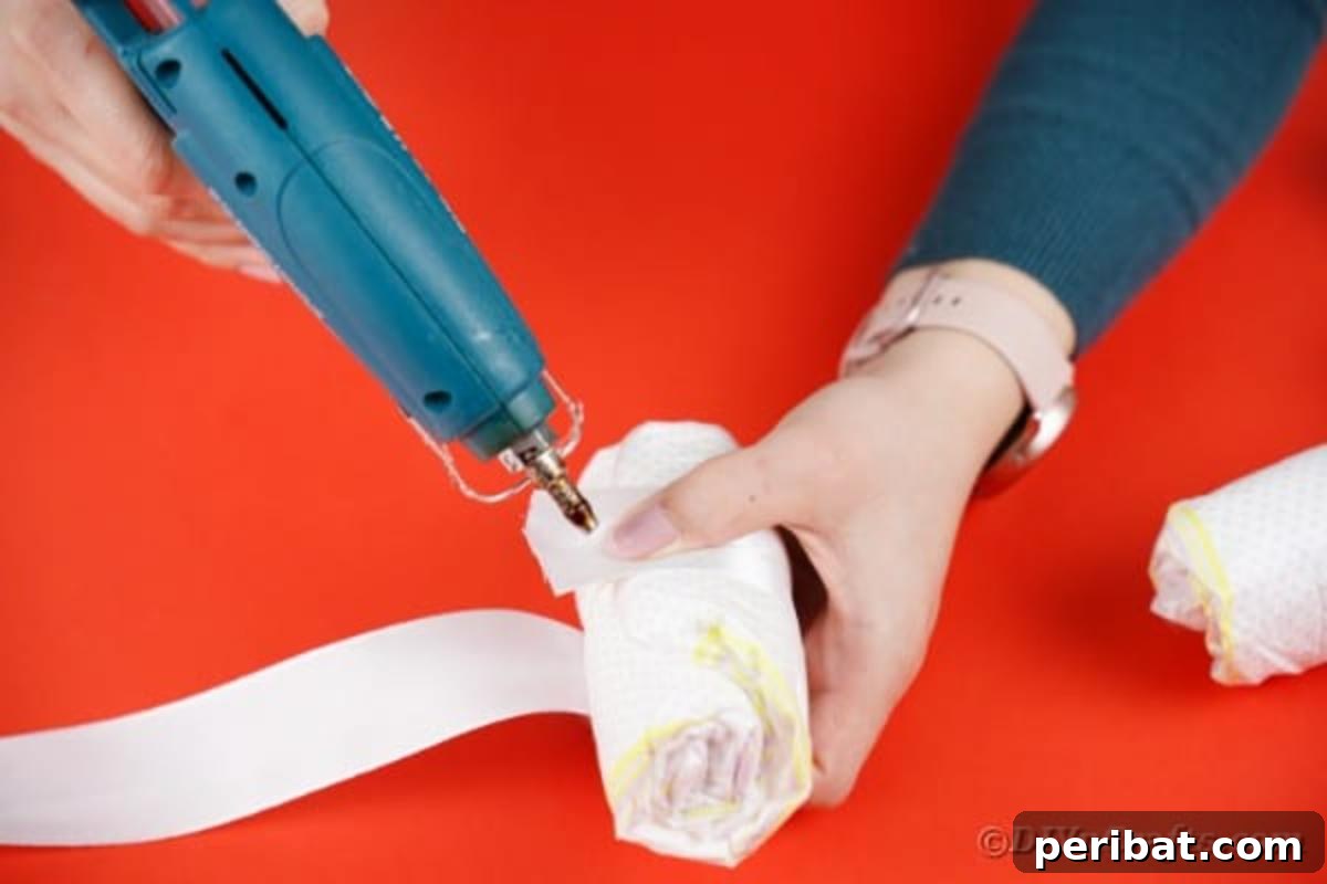 White ribbon being carefully wrapped around the middle of a diaper