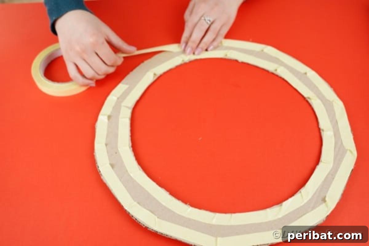 Double-sided tape being applied to the inner and outer edges of the cardboard wreath form