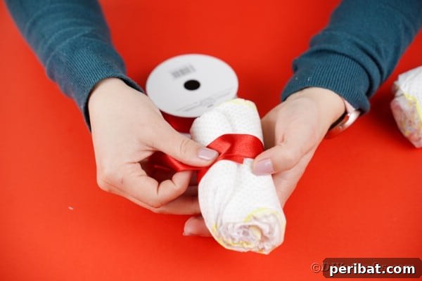 Wrapping diaper in red ribbon