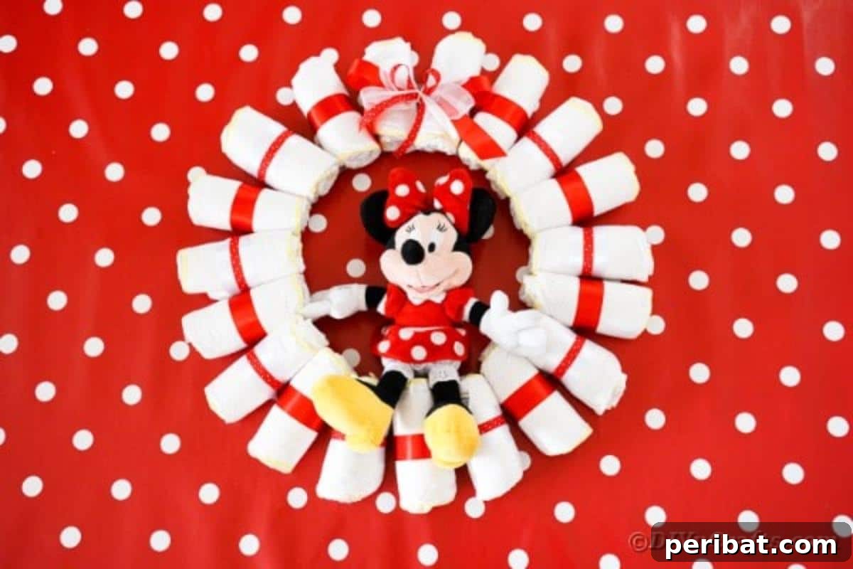 A beautifully arranged Minnie Mouse diaper wreath set against a festive red polka dot background
