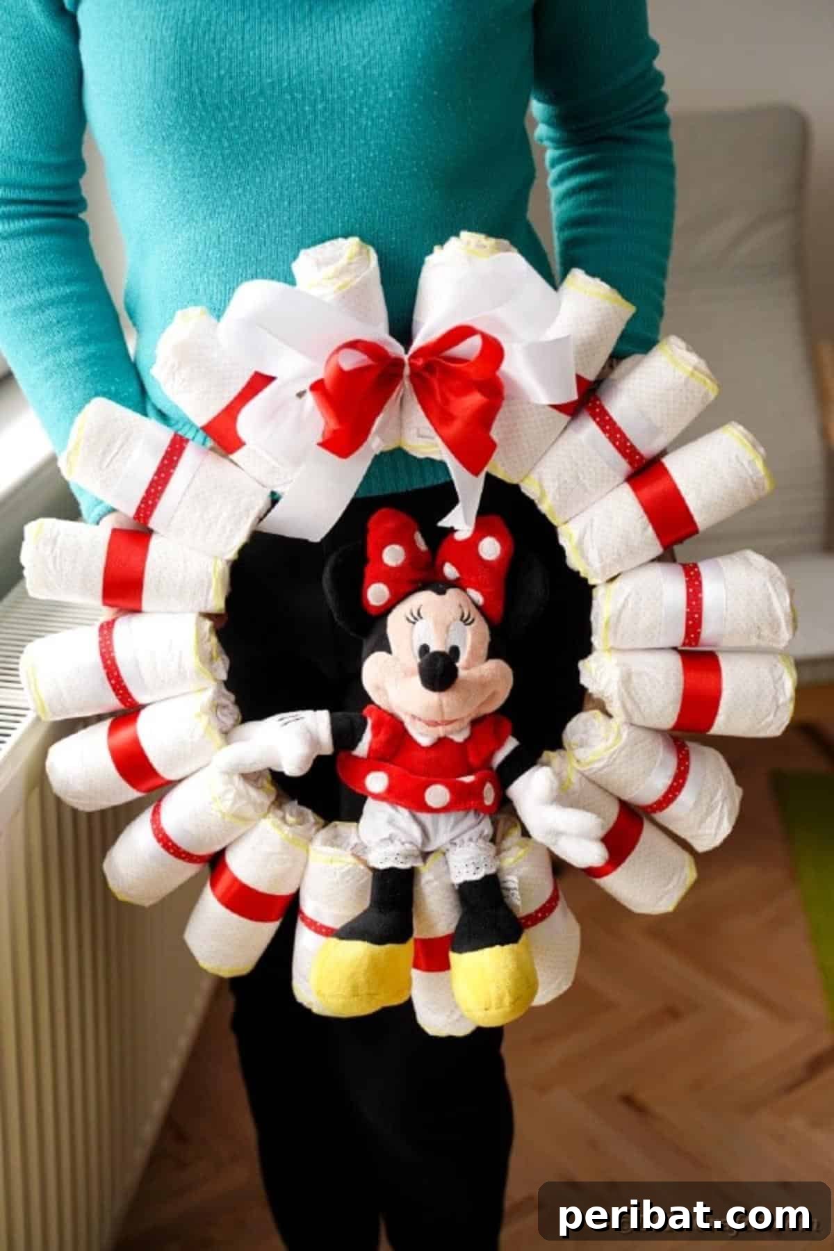 Woman holding a charming Minnie Mouse diaper wreath, perfect for a baby shower gift