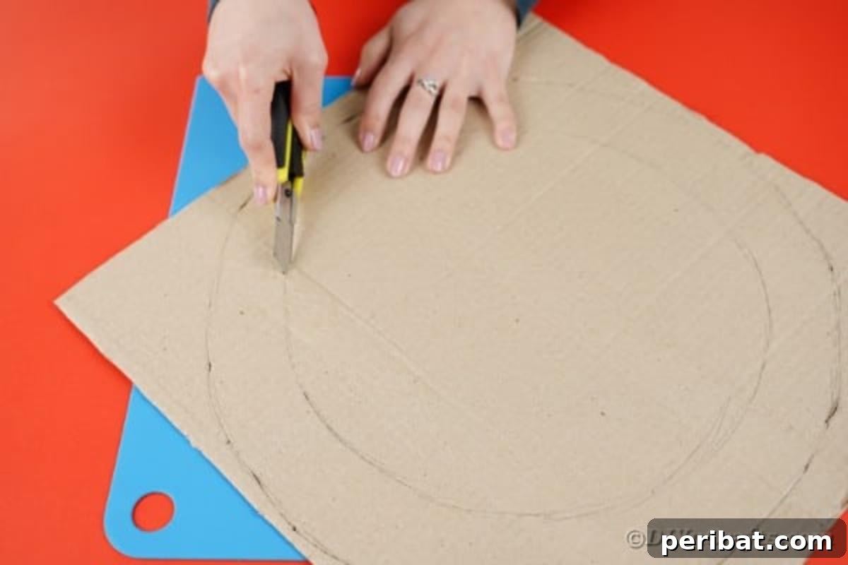 Woman carefully cutting a large circle out of cardboard to form the wreath base