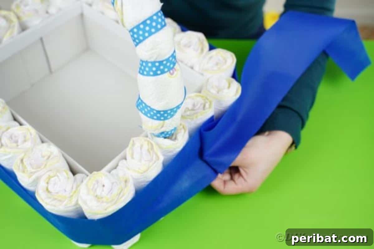 Charming Handmade Diaper Tub Shower Present 18 Wrapping a strip of blue tissue paper around the diaper-covered box