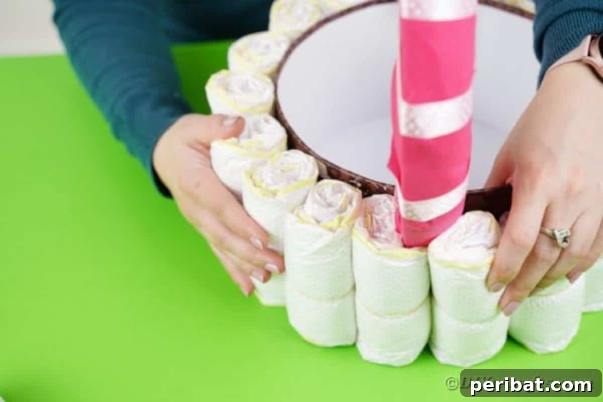 Charming Pink Handmade Diaper Basket Baby Shower Present 18 Continuing to stick rolled diapers around the round box until the entire surface is covered