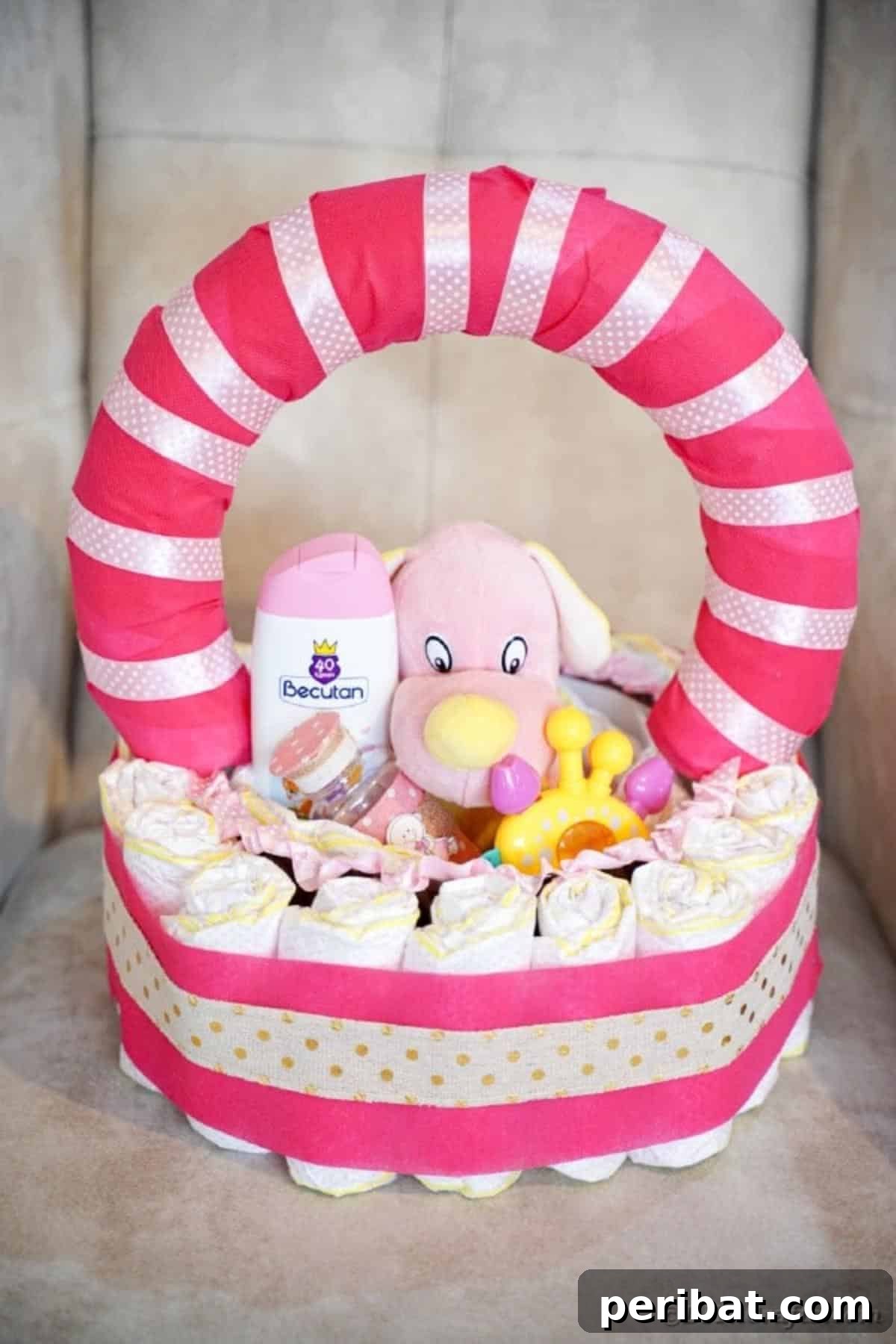 Charming Pink Handmade Diaper Basket Baby Shower Present 4 DIY diaper basket with pink and gold ribbon on a white chair, showcasing its elegant handle