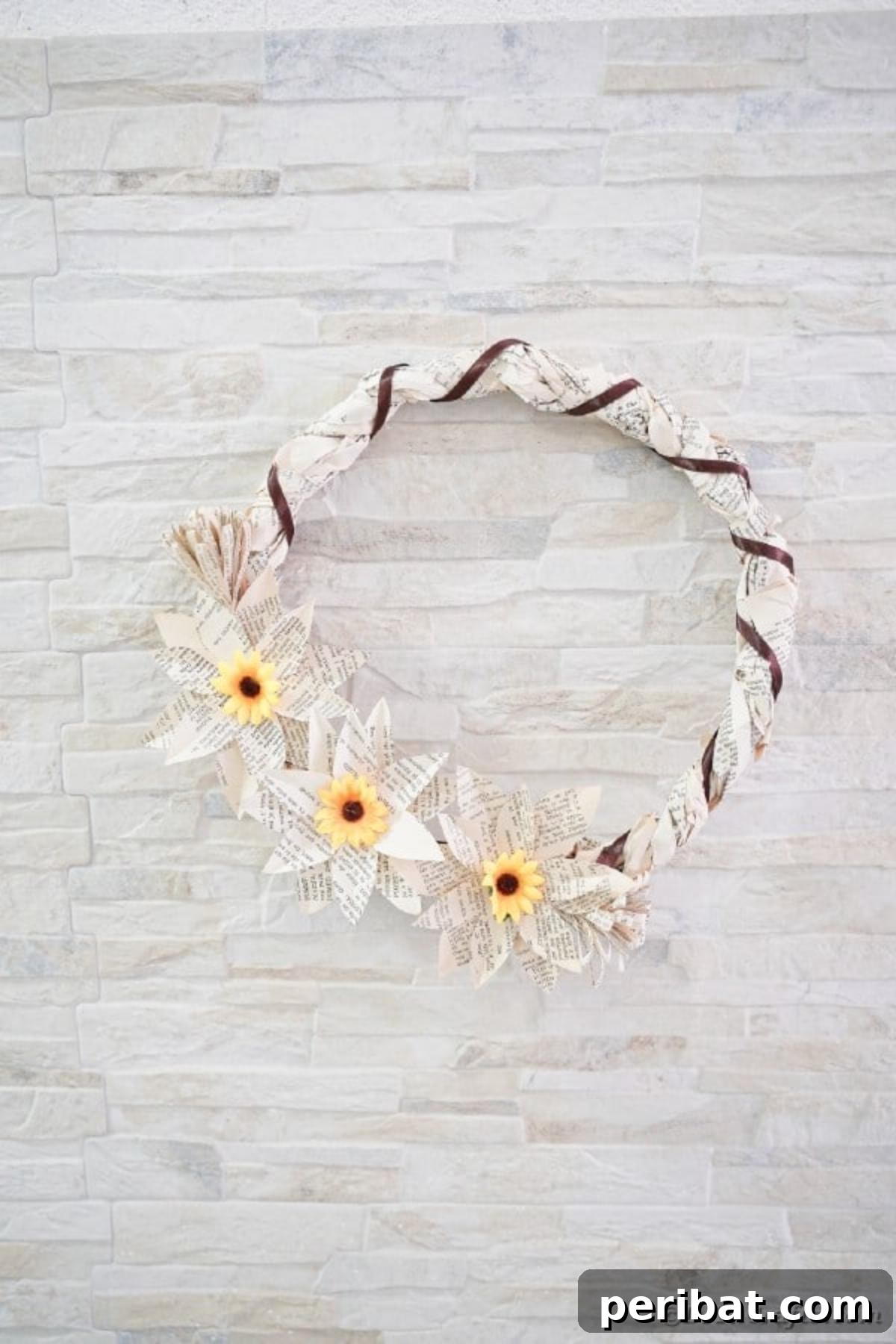 Book page wreath on brick wall