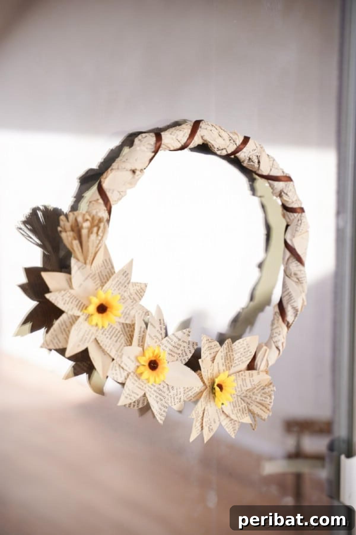 Book page grapevine wreath hanging on window