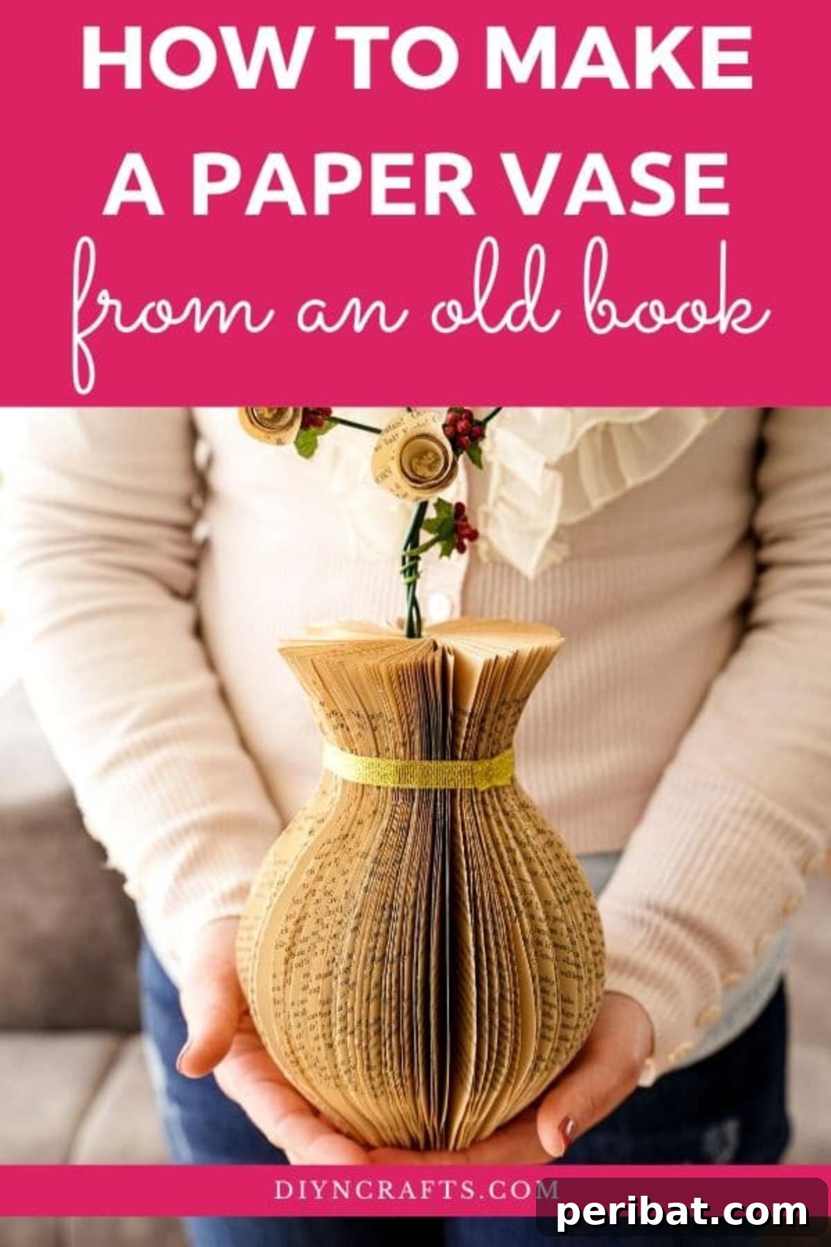 Woman holding a rustic paper vase made from old book pages, filled with delicate artificial flowers, showcasing its potential as a beautiful home decor item.