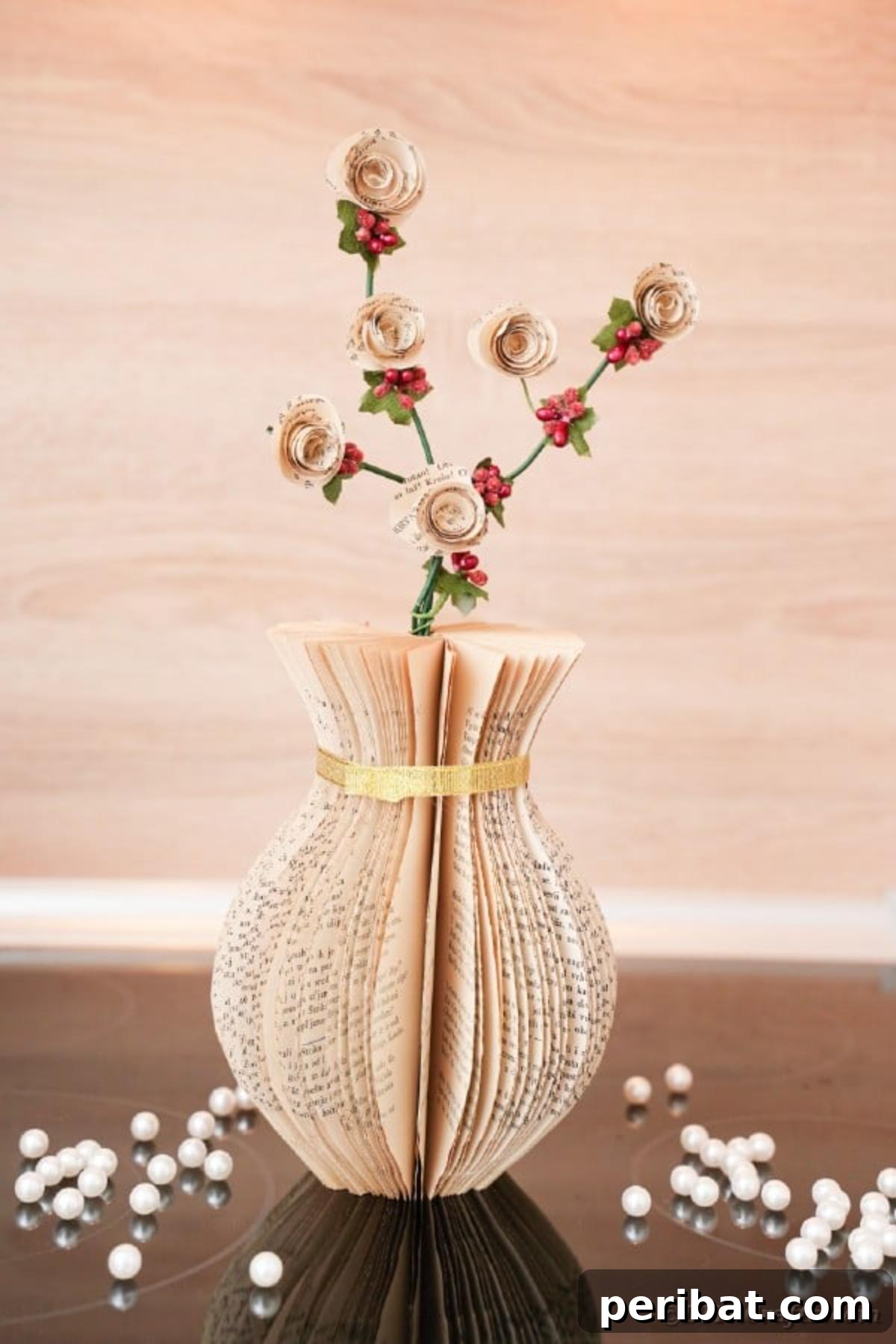 A meticulously crafted paper vase made from old book pages, adorned with a simple gold ribbon, sitting elegantly on a wooden table, ready to enhance any living space.