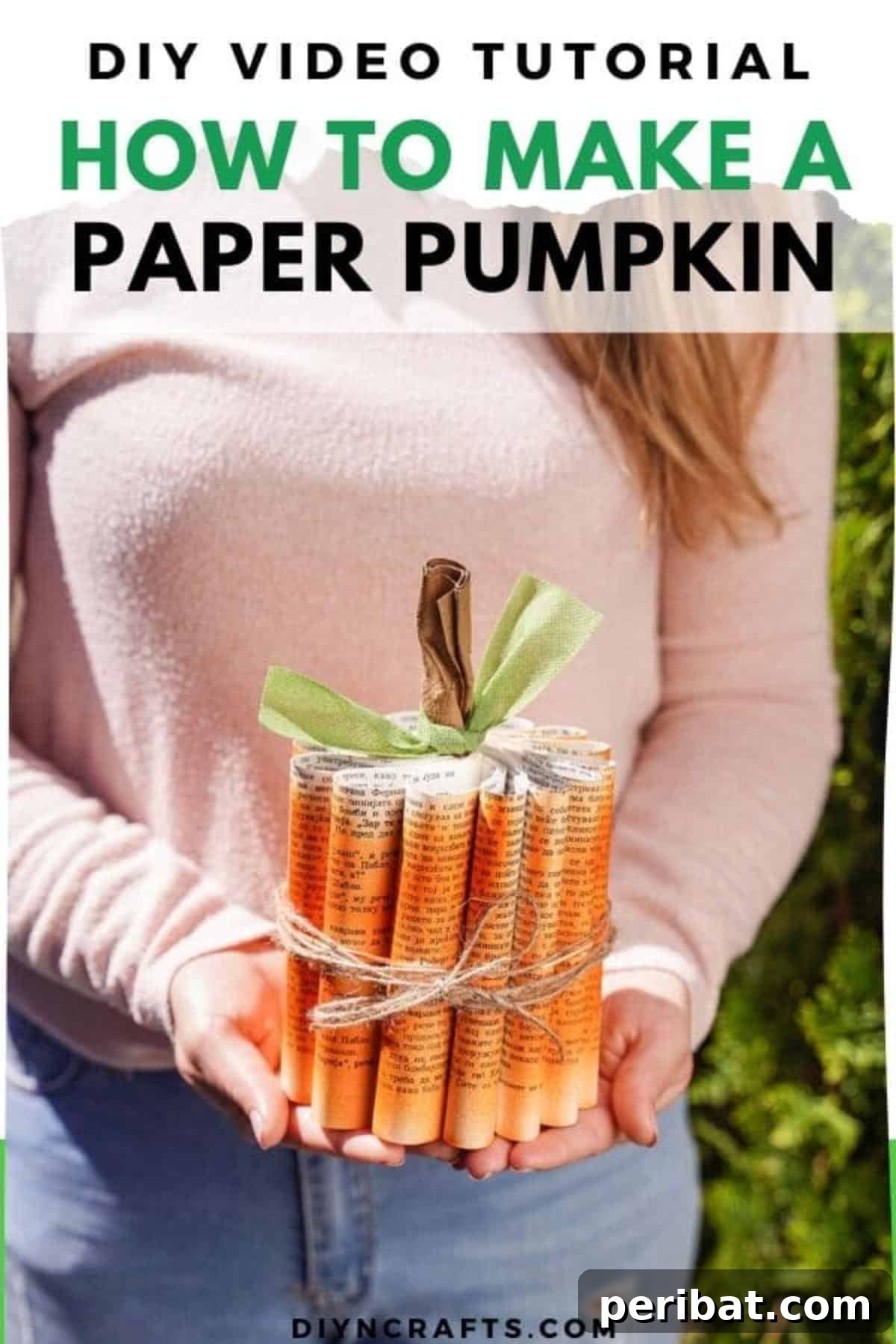 Storybook Pumpkin Charm 2 Woman in pink sweater holding a beautifully crafted paper pumpkin made from old book pages, showcasing its rustic charm.