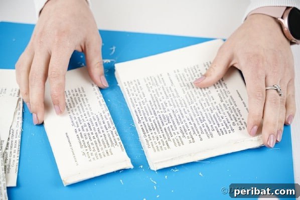Storybook Pumpkin Charm 10 Close-up of hands trimming the edges of the book pages with scissors.