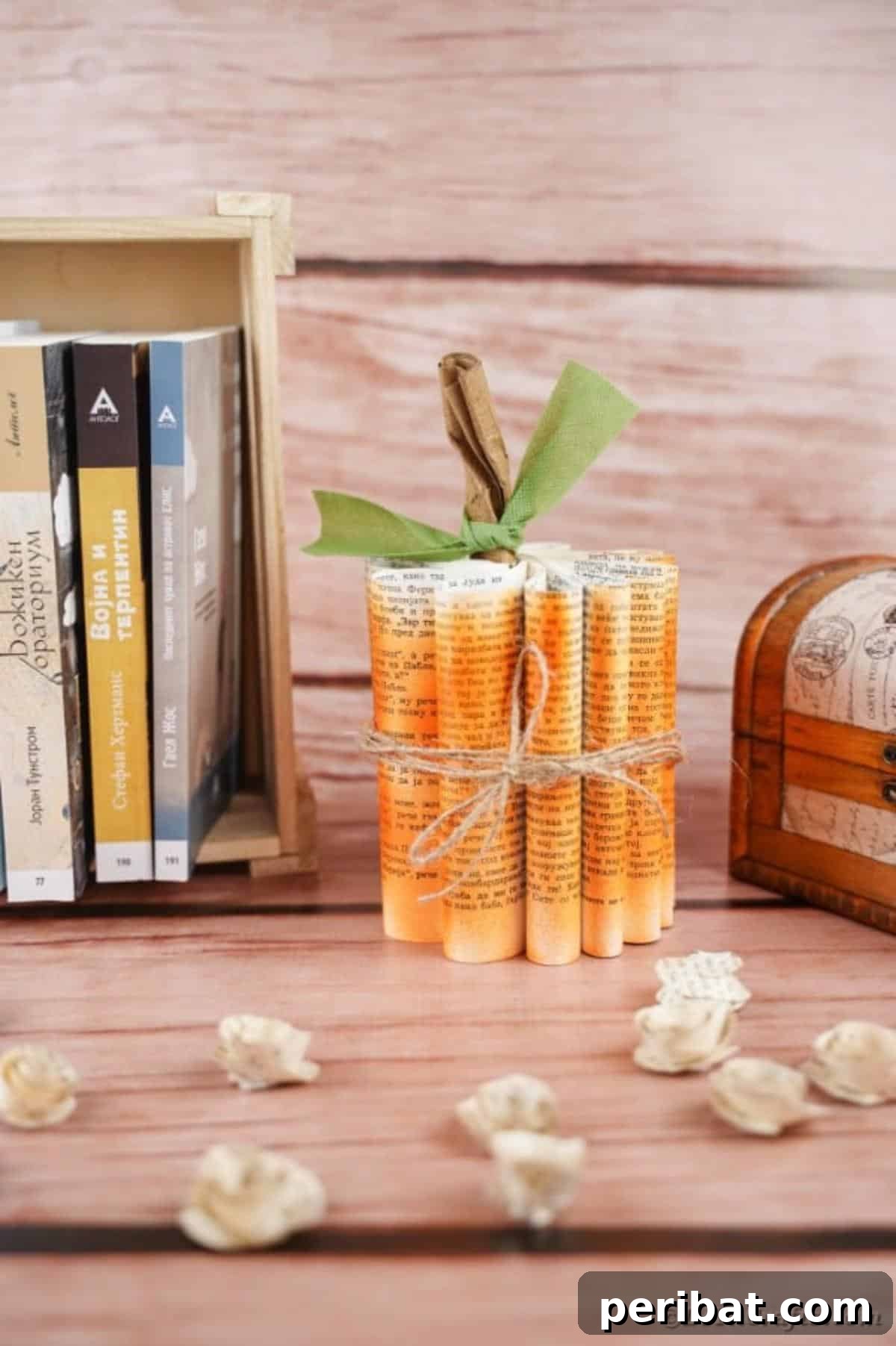 Storybook Pumpkin Charm 36 A detailed view of an old book page pumpkin next to a stack of books, highlighting the paper texture and rustic finish.