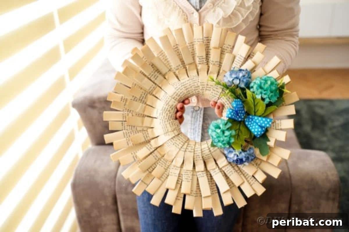 A woman gently holds a beautifully crafted folded paper wreath, showcasing the intricate detail of the book pages.