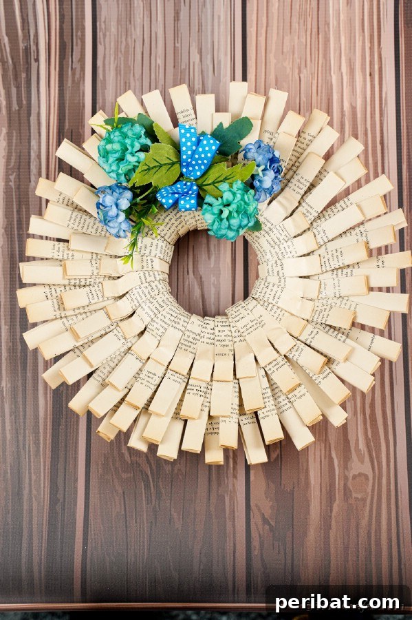A beautifully textured wreath, handcrafted from old book pages, rests elegantly on a warm wooden wall, highlighting its rustic charm.